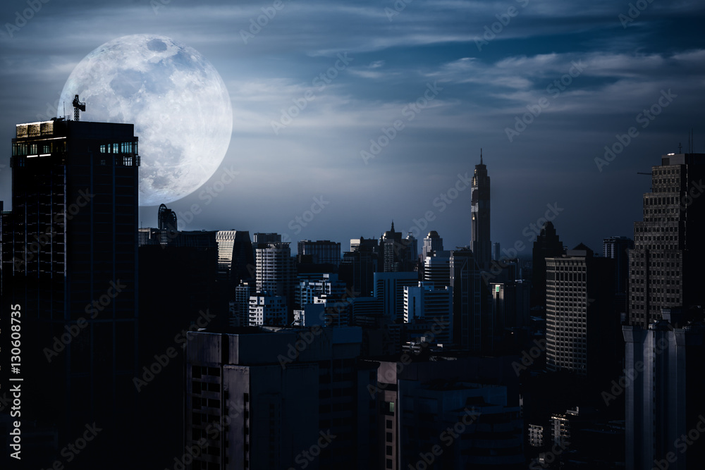 Silhouettes of skyscrapers different construction with backgroud of a full moon