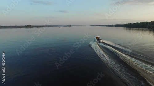 Wallpaper Mural A small motor boat very quickly glides over the surface of the river. The water ripple out trace of the boat. The camera follows the boat at low altitude. Aerial view. Torontodigital.ca