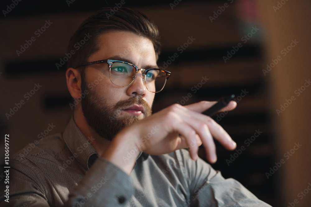Concentrated web designer looking at computer. Holding pen. Concentrated web designer looking at computer. Holding pen.