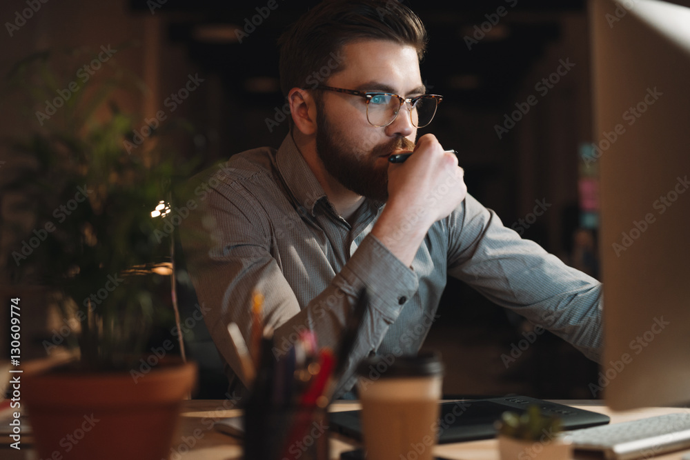 Obraz premium Designer working late at night and looking to computer