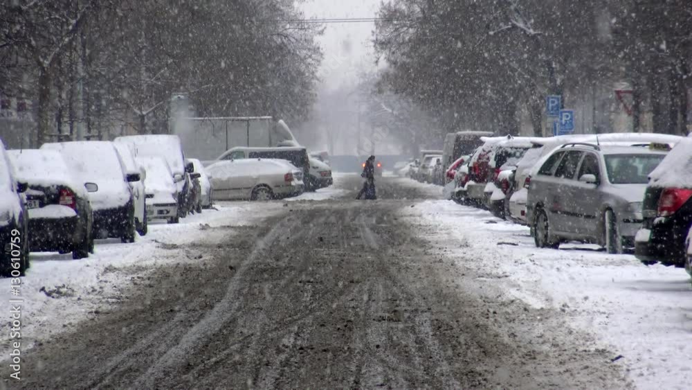 Snowy road with parked cars at heavy snowfall Snowy road with parked cars at heavy snowfall