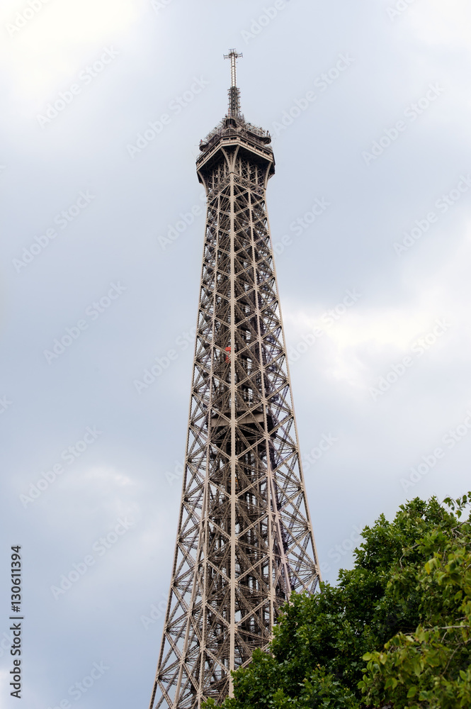 Detail of the Eiffel Tower on the background of a cloudy stormy sky. Detail of the Eiffel Tower on the background of a cloudy stormy sky.