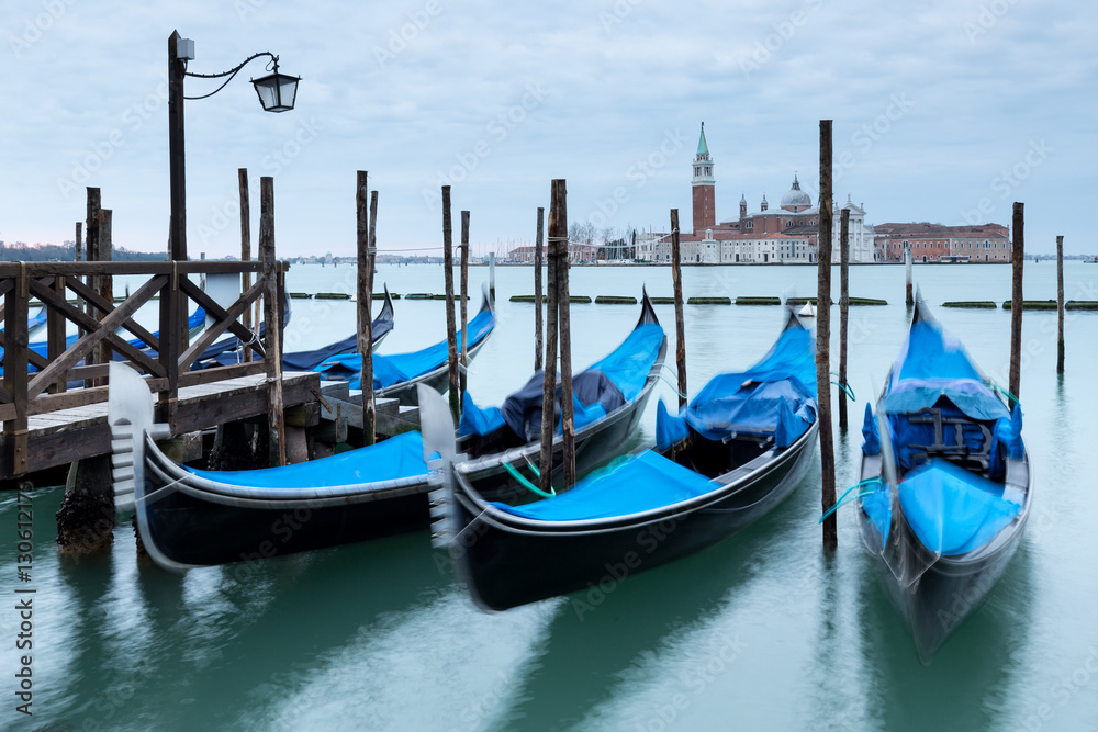View across the Grand Canal in Venice with three Gondolas in the foreground.