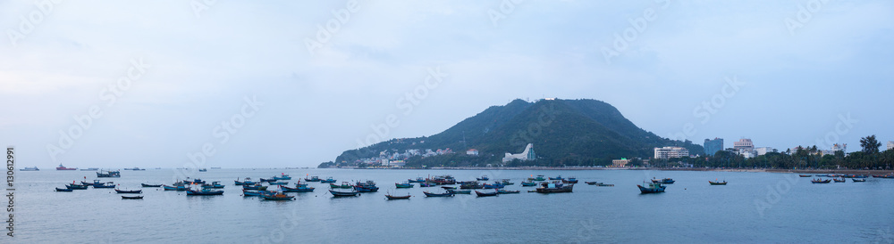 Panorama of port city with mountains and fishing boats