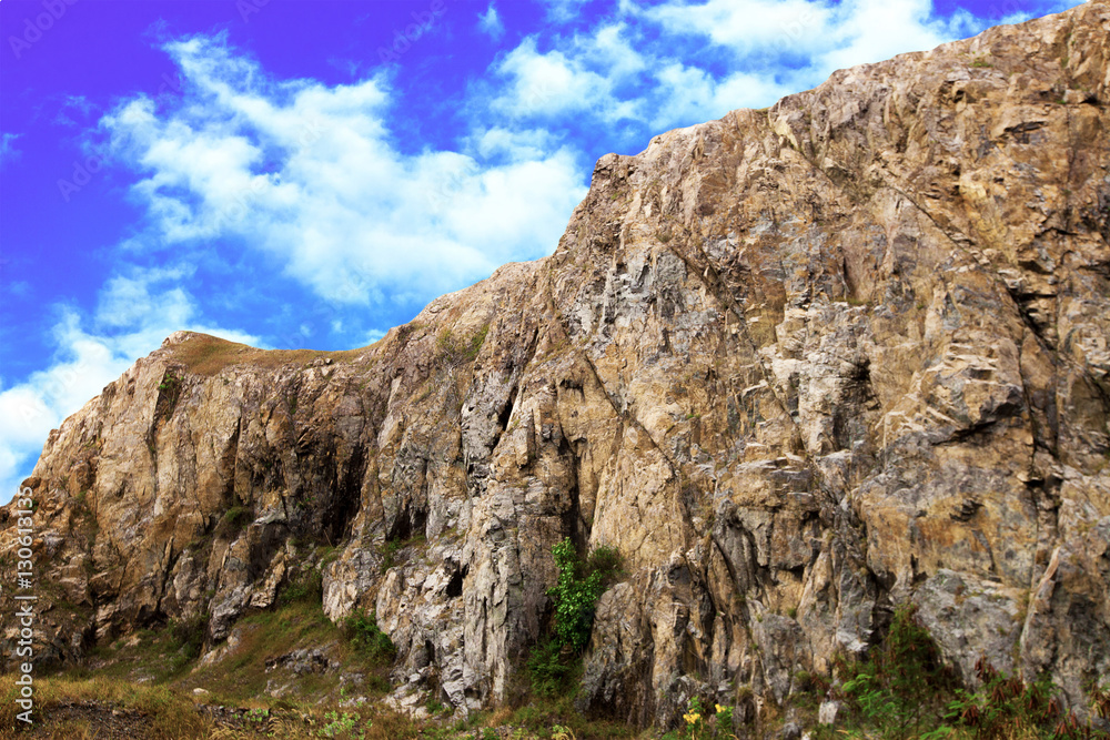 Rock on background of cloudy sky