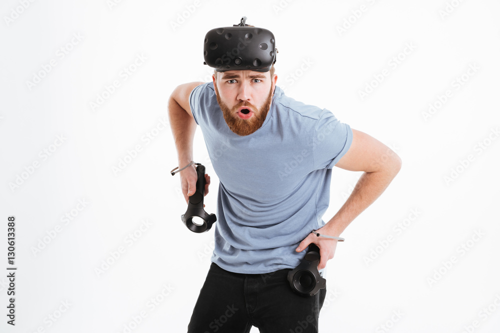 Young confused man wearing virtual reality device Young confused man wearing virtual reality device