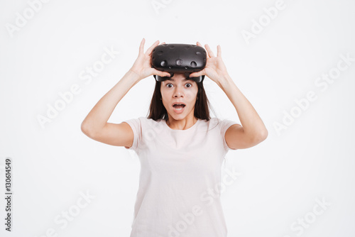 Shocked young woman wearing virtual reality device