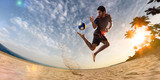 Beach soccer player in action. Sunny beach wide angle and sea