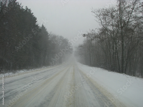 Side road in the forest during the winter season covered with snow and ice