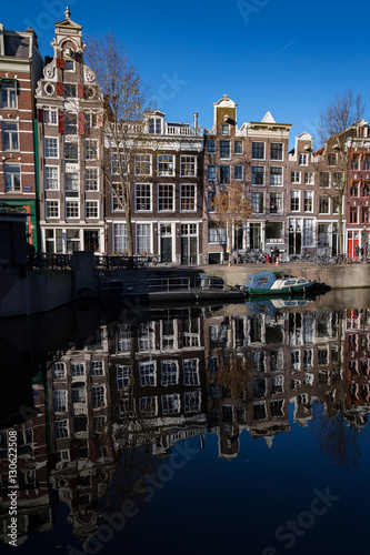 Amsterdam's converted warehouses reflect in one of its canals