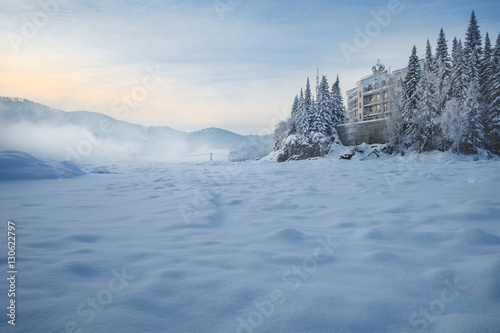 Castle on the River/The hotel, which stands on the bank of a frozen river. In its windows reflect the light of the rising sun. Katun River, Mountain Altai, Siberia, Russia
