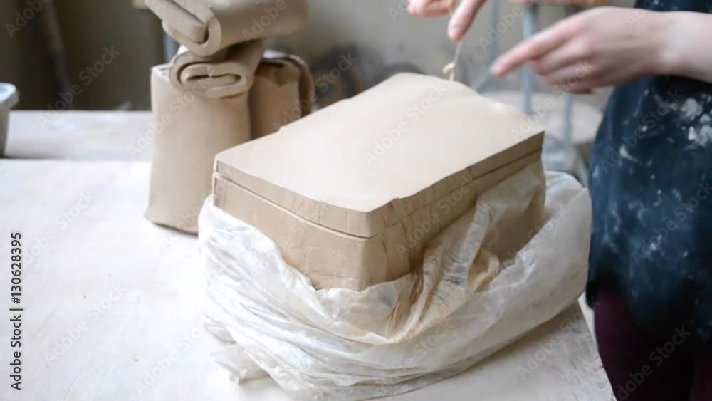 man cutting the clay before you begin sculpting close-up In workshop