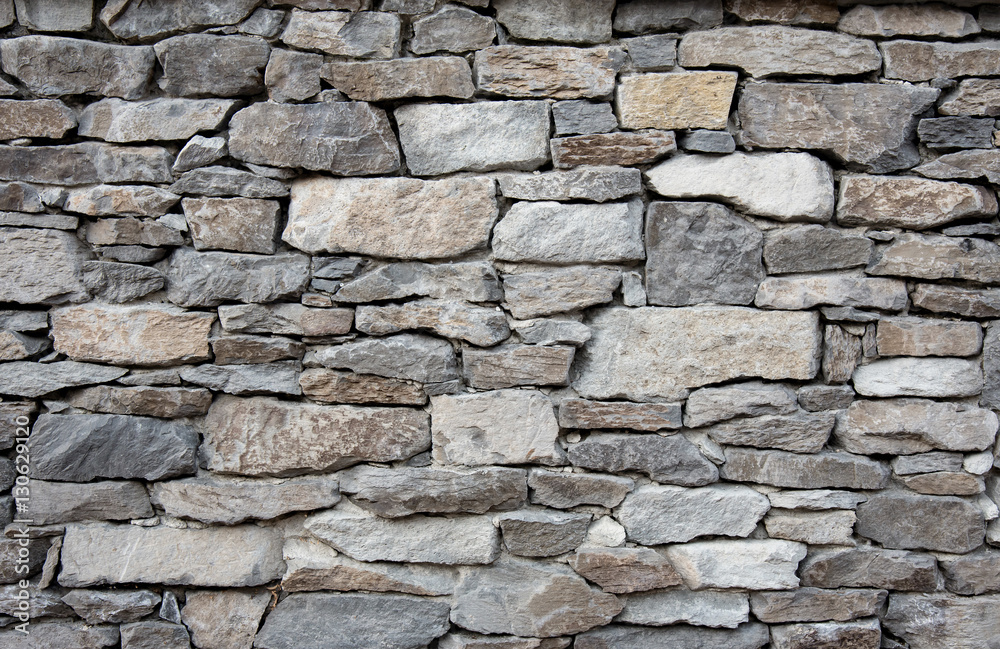 Photo & Art Print Grey stone wall with different sized stones, modern siding