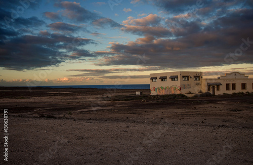 tramonta il sole su una struttura abbandonata tra deserto e mare © gpriccardi