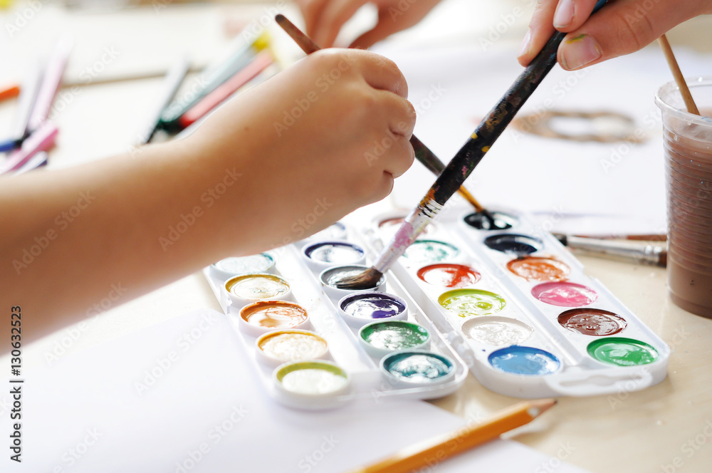 Hands of child painting with paintbrush Hands of child painting with paintbrush