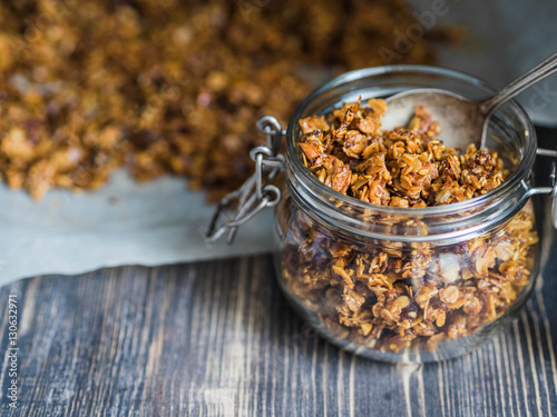 Open glass jar with homemade granola 
 photo