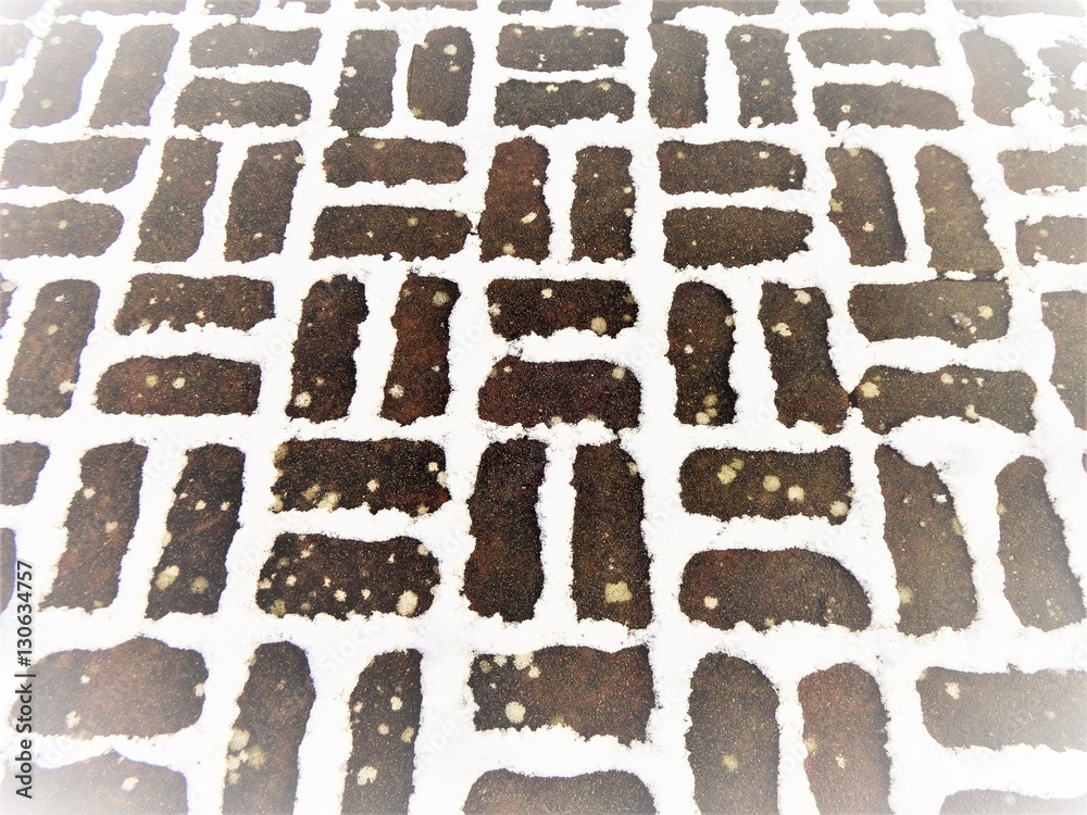 Snow on brick pavement