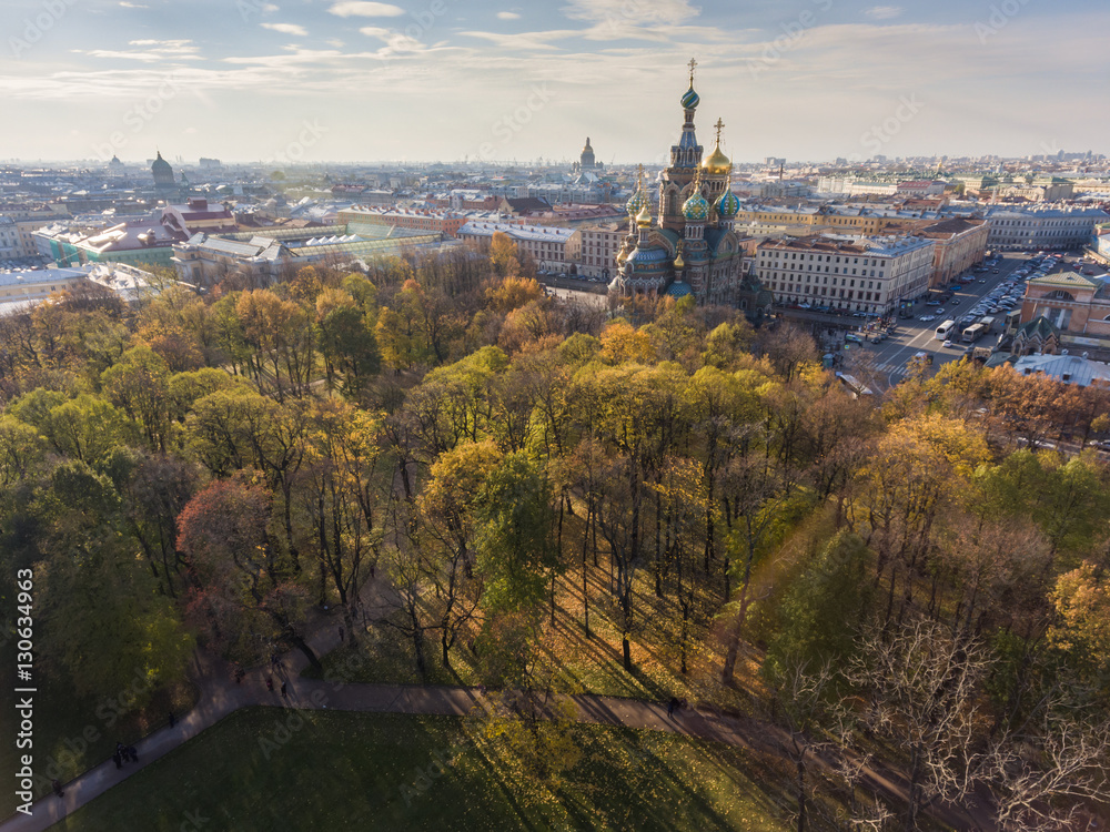 Russia, Saint-Petersburg, 24 October 2016: Aerial view of the cathedral Church of the Savior on Blood, gold domes, roofs of St. Petersburg, power, a panorama field of Mars, shadows of trees, autumn