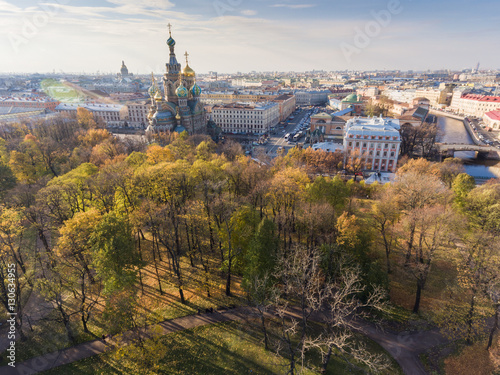 Russia, Saint-Petersburg, 24 October 2016: Aerial view of the cathedral Church of the Savior on Blood, gold domes, roofs of St. Petersburg, power, a panorama field of Mars, shadows of trees, autumn
