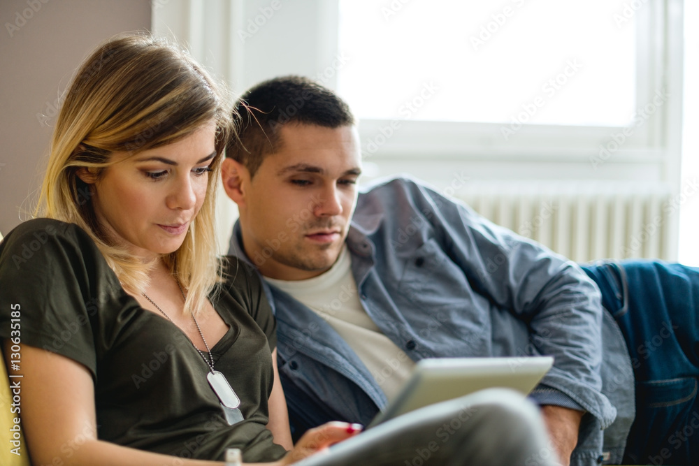 Young couple looking at digital tablet