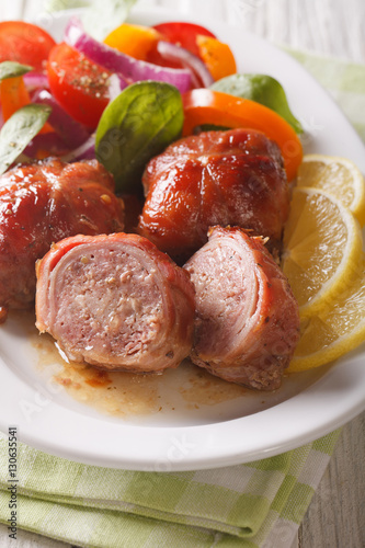 Baked rabbit fillet and salad of tomatoes, peppers, spinach and onion close-up. vertical