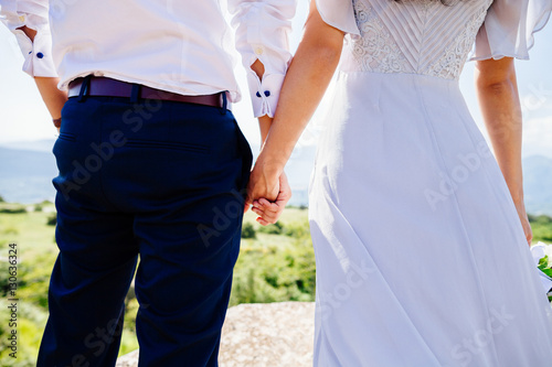 bride and groom holding hands together