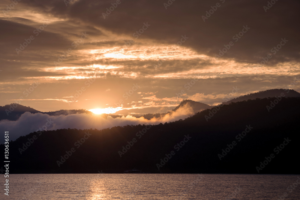 Sunrise on the lake. Mountain with cloudy sunrise morning.