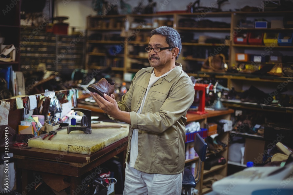 Shoemaker examining a shoe Shoemaker examining a shoe