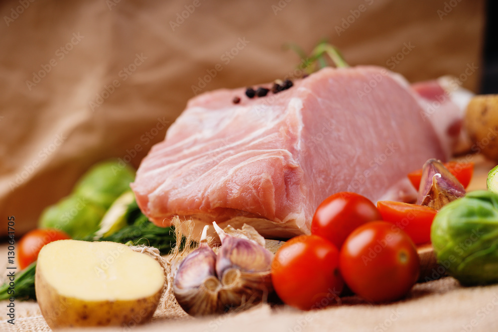 Raw pork and vegetables on a canvas background Raw pork and vegetables on a canvas background