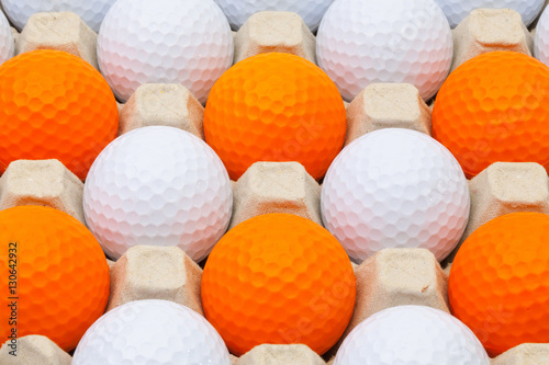 White and orange golf balls in the box