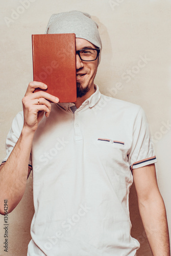 Portrait of handsome bearded man reading a book