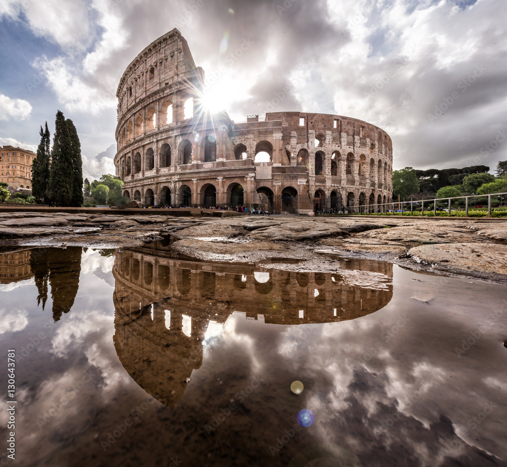 Roman Colosseum at sunrise with full reflection and beautiful sky