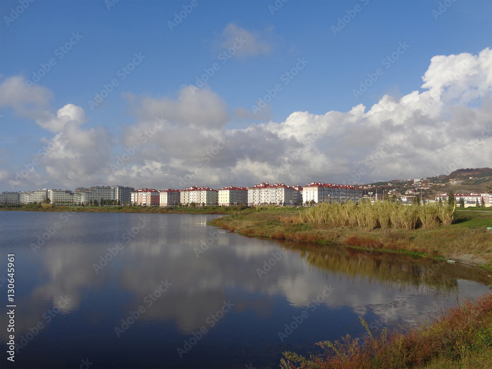  Apartment buildings and hotels on the shore of the lake, reflection clouds in water