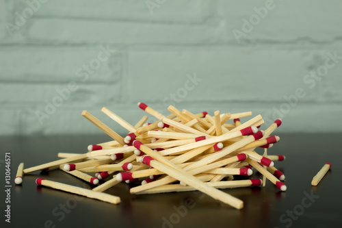 Pile of matches against brick wall background