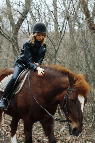 girl on horseback stroking her