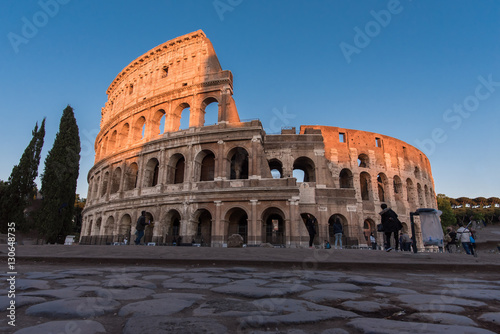 Roman coliseum at sunset with top lit up by evening sun