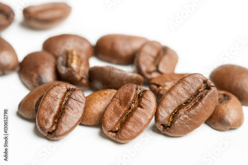 Granos de café en primer plano sobre fondo blanco aislado. Vista de frente. Macro