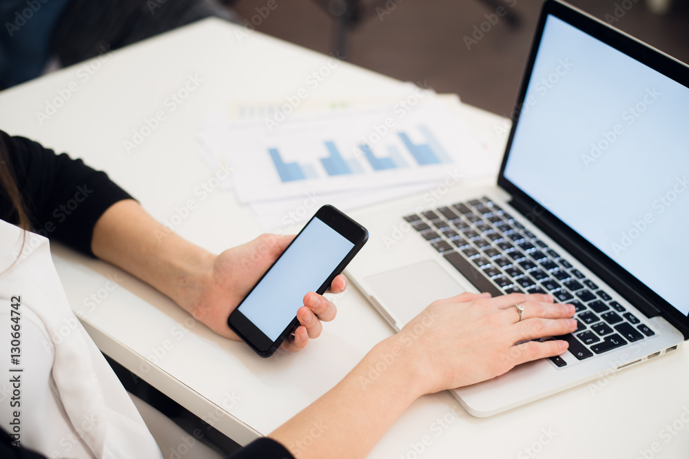 Close Up of woman hands using mobile phone and laptop computer with blank copy space screen for your advertising text message or content business. Close Up of woman hands using mobile phone and laptop computer with blank copy space screen for your advertising text message or content business.