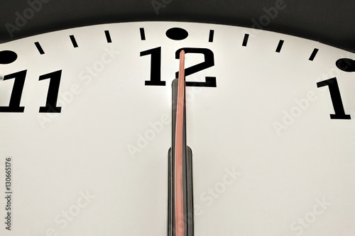 Uhr zeigt punkt zwölf oder mitternacht photo