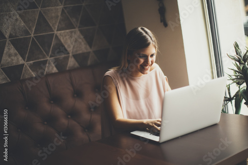Young woman with laptop sit...