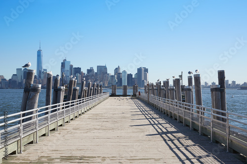 New York city skyline view and empty pier with seagulls in a sunlight © andersphoto