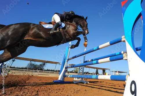 Rider on horse jumping over a hurdle during the equestrian event