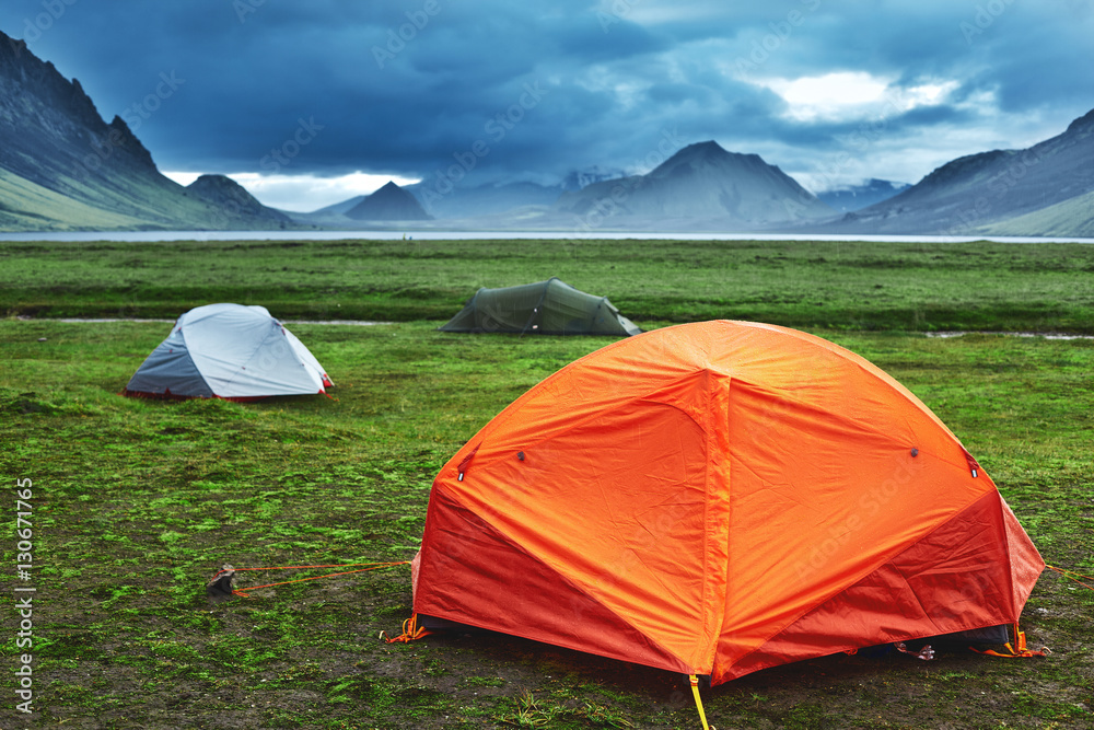 Travel to Iceland. Beautiful Icelandic landscape with mountains, sky and clouds. Trekking in national park Landmannalaugar. Rainy Evening in Camping near Alftavatn lake.