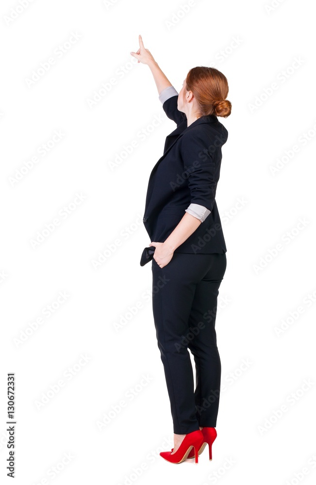Back view of young redhead business woman pointing at wal Back view of young redhead business woman pointing at wal