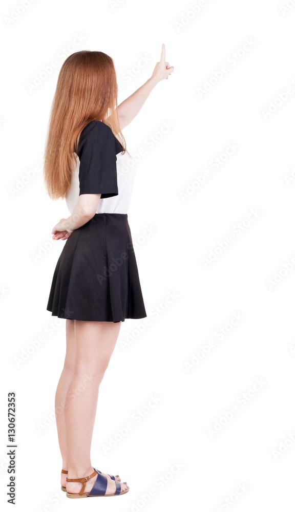 Back view of young redhead woman pointing at wall. beautiful gir Back view of young redhead woman pointing at wall. beautiful gir