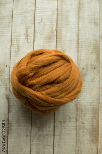 Brown merino wool ball on wooden background