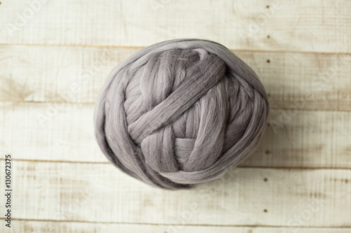 Grey merino wool ball on wooden background