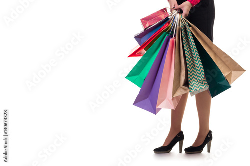 Lower close-up, girl stands holding shopping paper bags and pack
