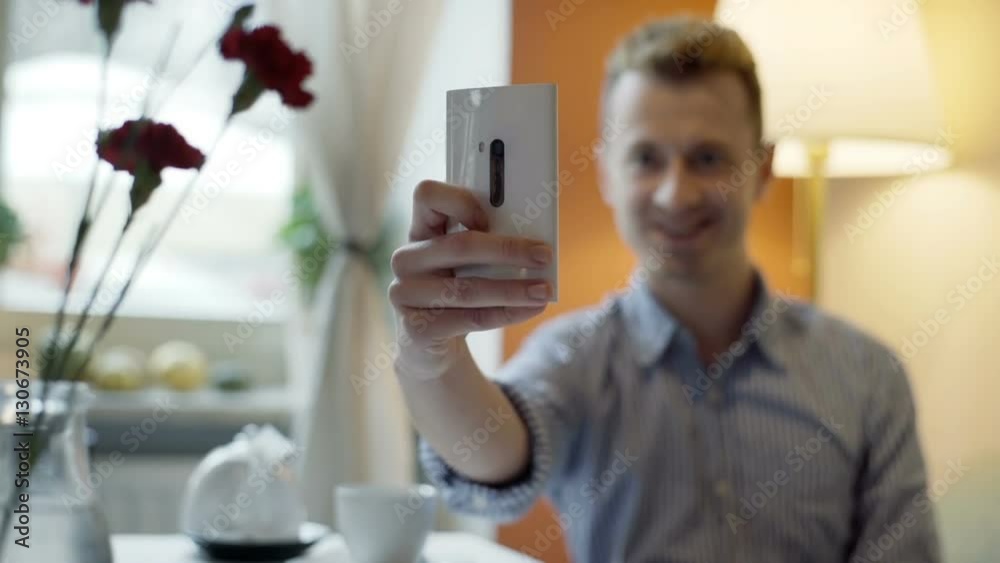Happy man sitting in the cafe and doing selfies on smartphone
Happy man sitting in the cafe and doing selfies on smartphone