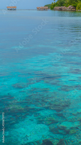 Bay with Underwater Corals in Front of Diving Station and Guesthouses on Kri Island, Raja Ampat, Indonesia, West Papua